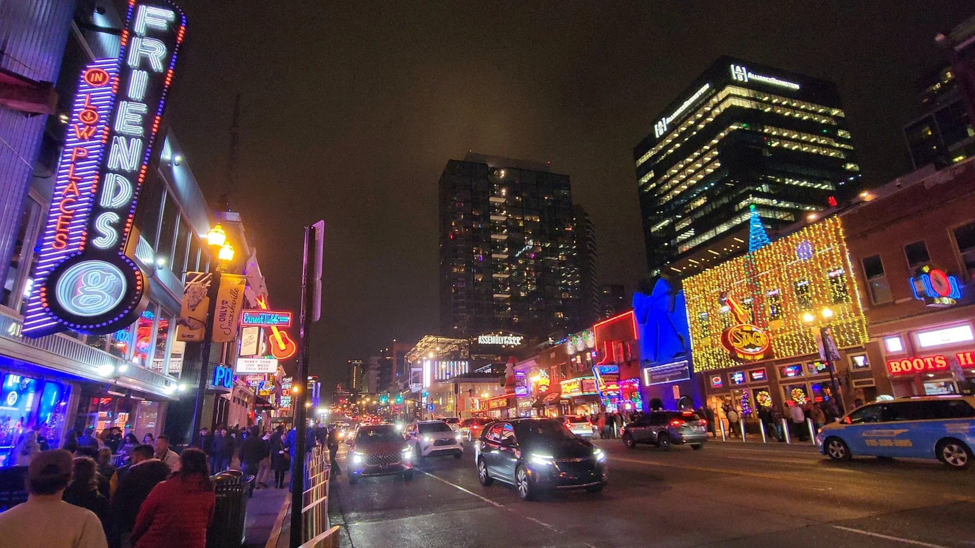 Lower Broadway glowing with neon signs at night.
